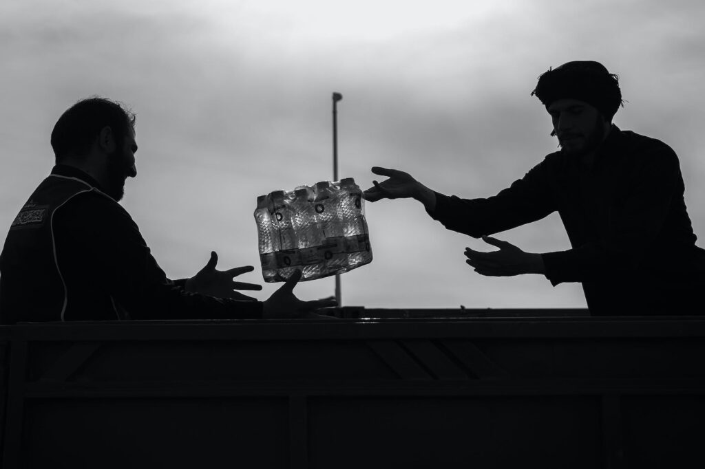 man passing case of bottles