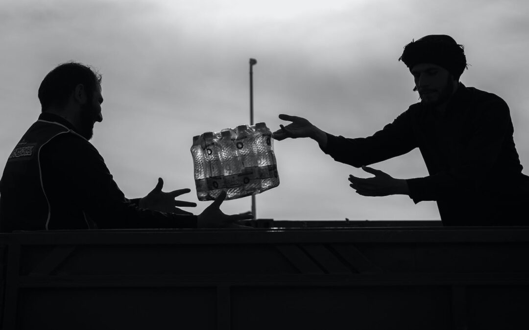 man passing case of bottles